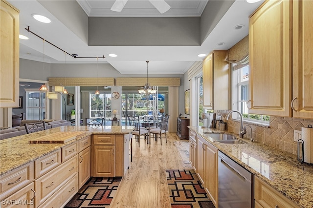 kitchen with dishwasher, hanging light fixtures, and light brown cabinetry