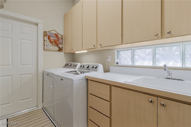 laundry room with washer and clothes dryer, cabinets, and sink