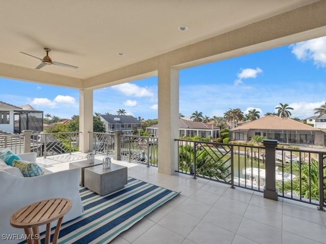 view of patio with ceiling fan, a water view, and a balcony