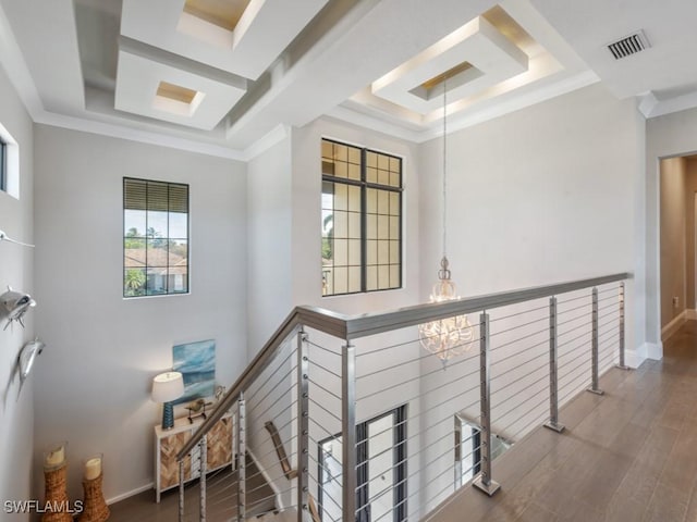 stairway featuring wood-type flooring, a tray ceiling, and crown molding