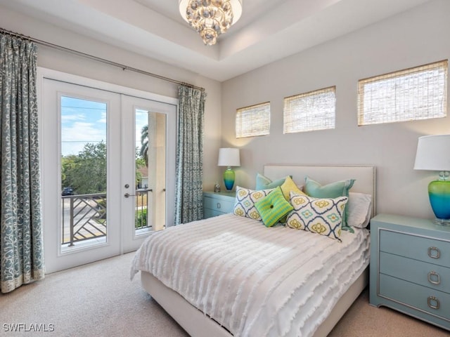 carpeted bedroom featuring a chandelier, access to outside, and a raised ceiling