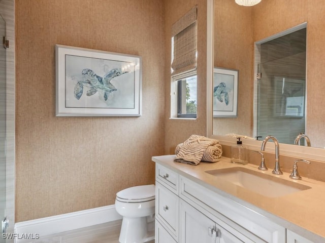 bathroom with hardwood / wood-style floors, vanity, toilet, and a shower with shower door