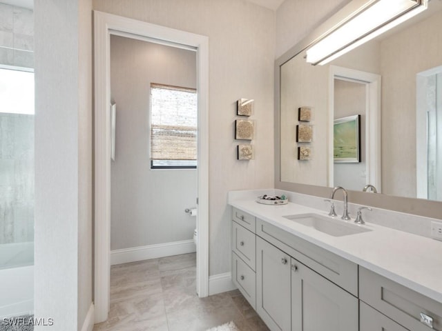 bathroom with tile patterned floors, vanity, a healthy amount of sunlight, and toilet