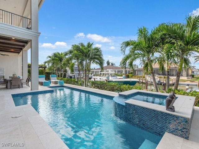 view of pool featuring a water view, an in ground hot tub, and a patio