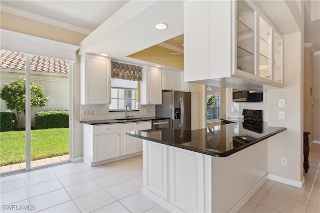 kitchen with appliances with stainless steel finishes, sink, white cabinets, kitchen peninsula, and crown molding