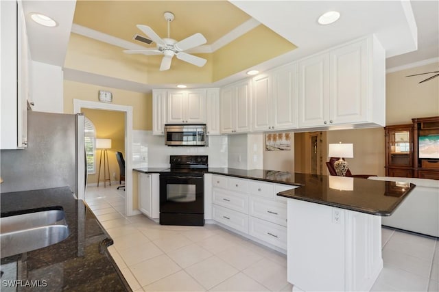 kitchen featuring white cabinetry, appliances with stainless steel finishes, kitchen peninsula, and a raised ceiling