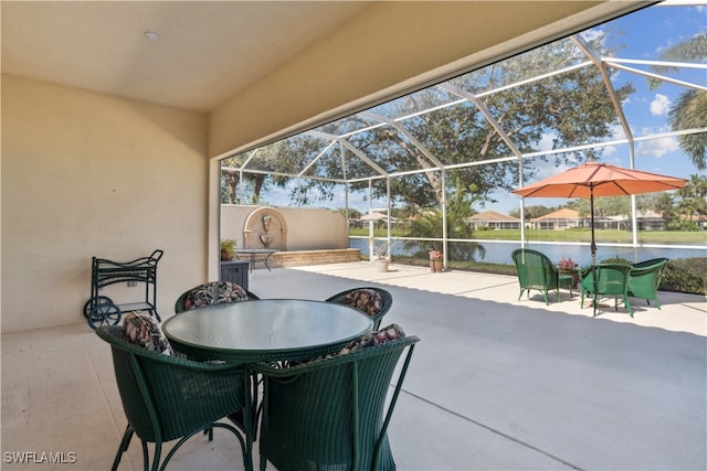 view of patio featuring a water view and glass enclosure