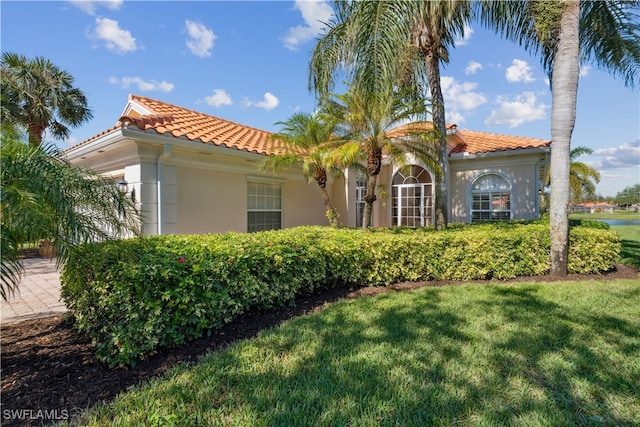 mediterranean / spanish house featuring a front lawn