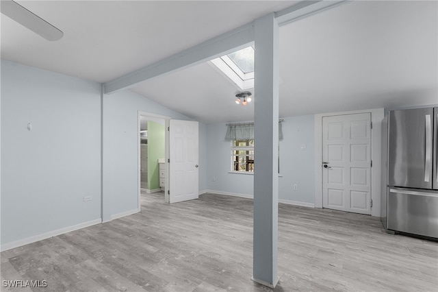 interior space featuring lofted ceiling with skylight and light wood-type flooring