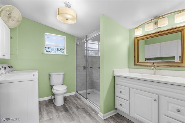 bathroom featuring walk in shower, vanity, vaulted ceiling, hardwood / wood-style floors, and washing machine and dryer