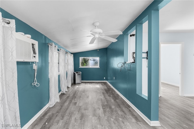 interior space with hardwood / wood-style floors, an AC wall unit, and ceiling fan