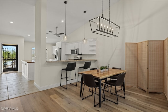 dining area featuring light hardwood / wood-style flooring and a high ceiling