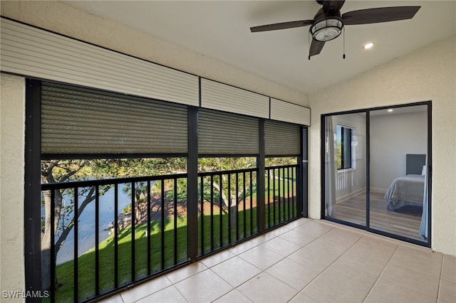 unfurnished sunroom featuring ceiling fan, vaulted ceiling, and a healthy amount of sunlight