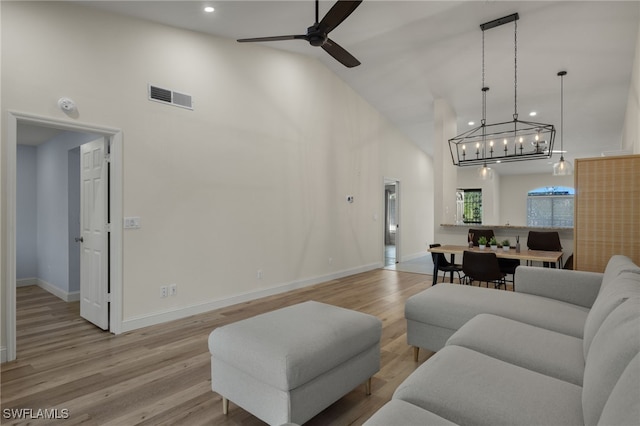 living room featuring ceiling fan, high vaulted ceiling, and light hardwood / wood-style floors