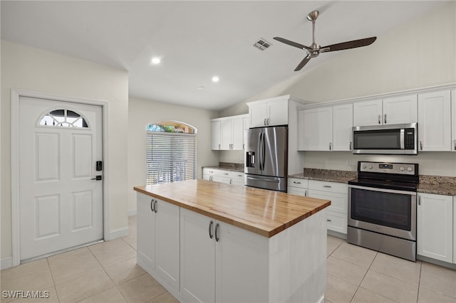 kitchen featuring stainless steel appliances, butcher block countertops, and white cabinets