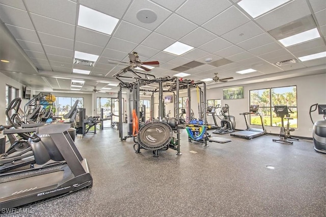 exercise room with a drop ceiling and ceiling fan