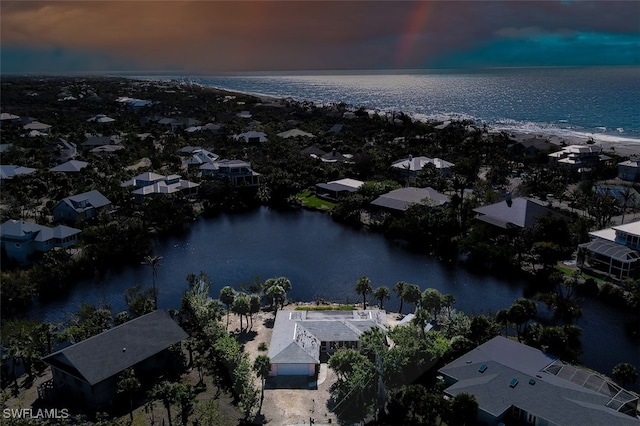 aerial view at dusk featuring a water view