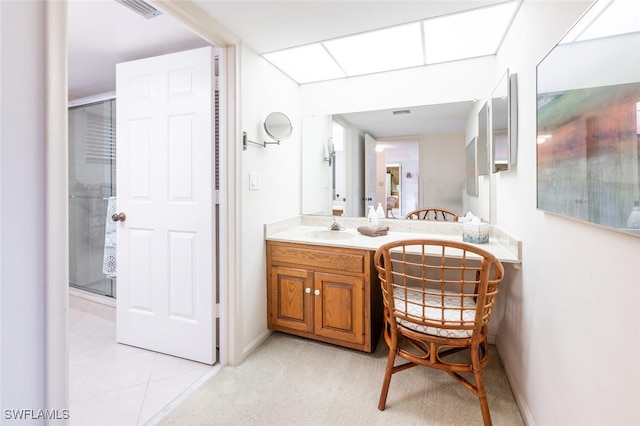 bathroom featuring tile patterned flooring, vanity, and an enclosed shower