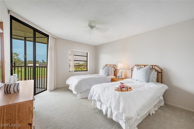 bedroom featuring access to outside, ceiling fan, light carpet, and a textured ceiling