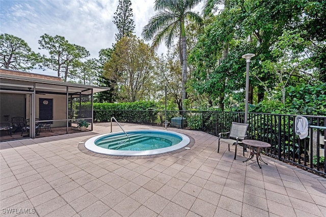 view of swimming pool with a sunroom, a patio, and an in ground hot tub