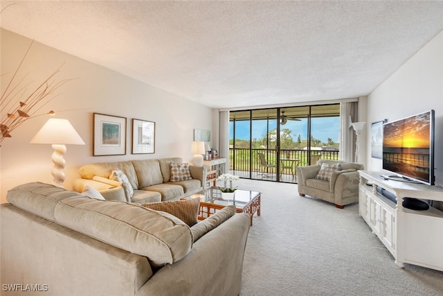 living room with a textured ceiling, light colored carpet, and expansive windows