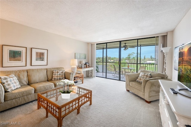 living room featuring expansive windows, light colored carpet, and a textured ceiling