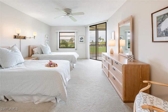 carpeted bedroom with ceiling fan and access to outside