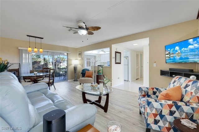 living room featuring ceiling fan and light hardwood / wood-style floors