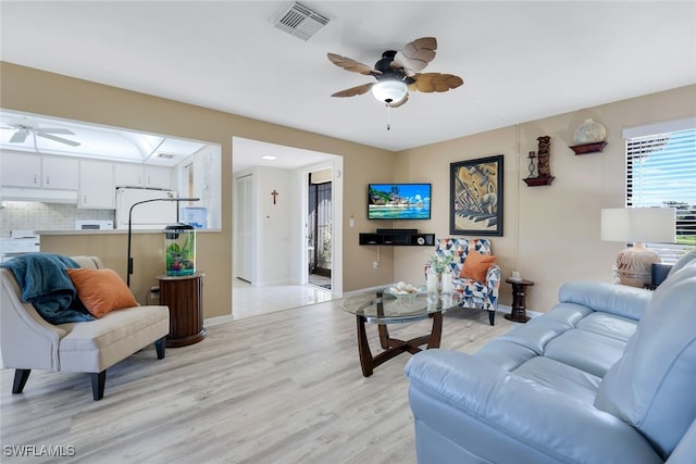 living room with ceiling fan and light wood-type flooring