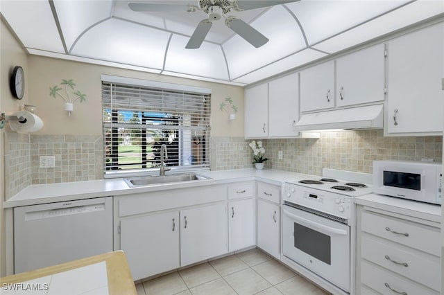 kitchen with white appliances, light tile patterned floors, sink, premium range hood, and white cabinets