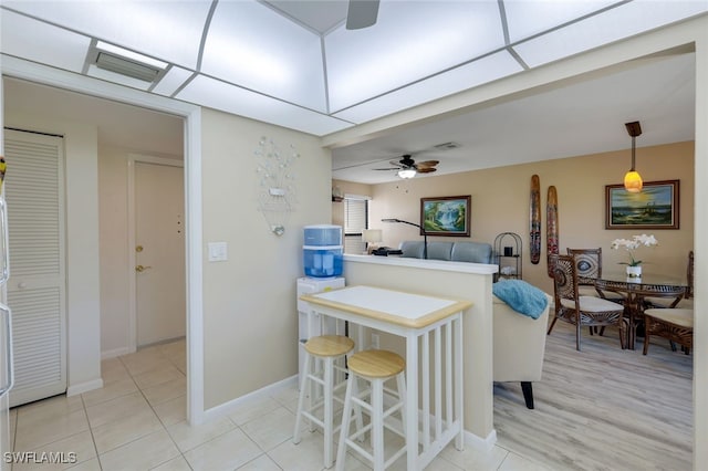 kitchen featuring ceiling fan, light tile patterned floors, and decorative light fixtures