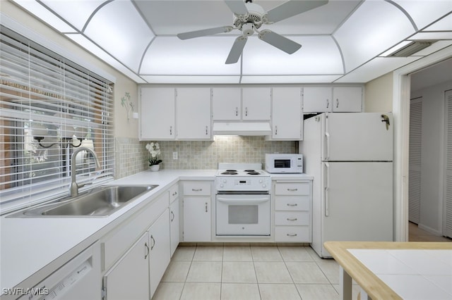 kitchen with backsplash, premium range hood, white appliances, sink, and white cabinetry