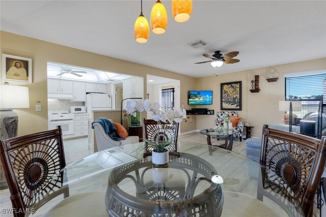 dining space featuring ceiling fan and light tile patterned floors