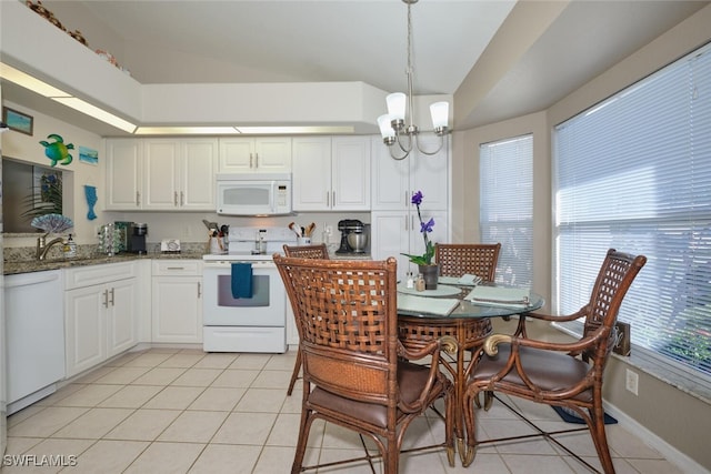 kitchen with white appliances, pendant lighting, an inviting chandelier, dark stone countertops, and white cabinetry