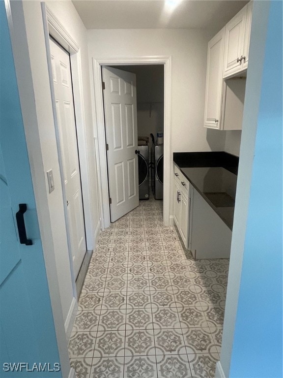 kitchen with white cabinets, washing machine and dryer, and light tile patterned floors