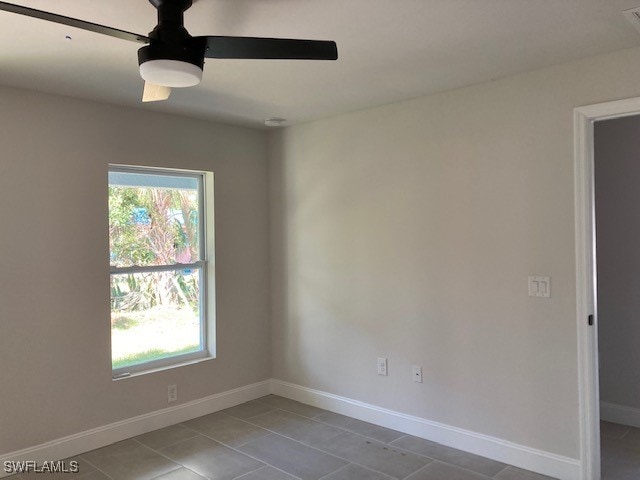 tiled spare room featuring ceiling fan