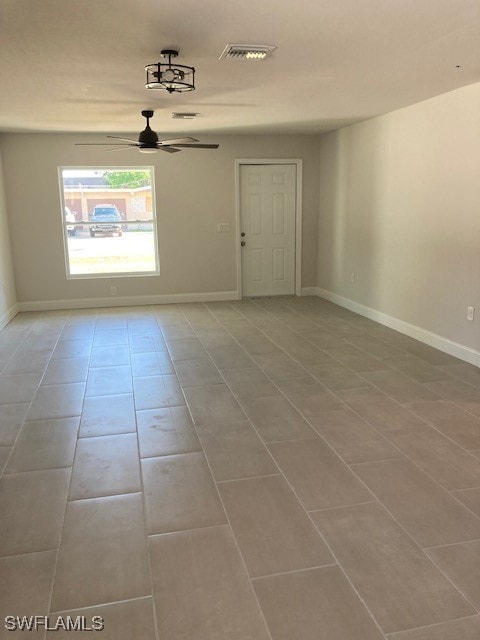 empty room featuring tile patterned floors and ceiling fan