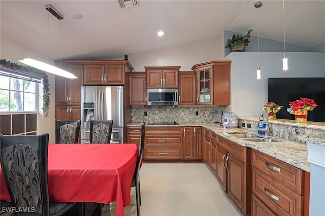 kitchen featuring pendant lighting, stainless steel appliances, vaulted ceiling, and sink