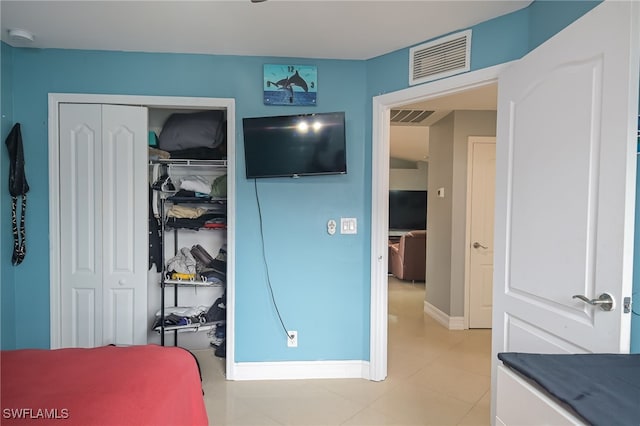 tiled bedroom with a closet