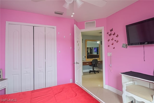 bedroom with tile patterned floors, ceiling fan, a closet, and built in desk