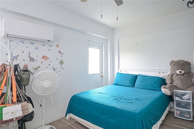 bedroom with an AC wall unit, ceiling fan, and wood-type flooring