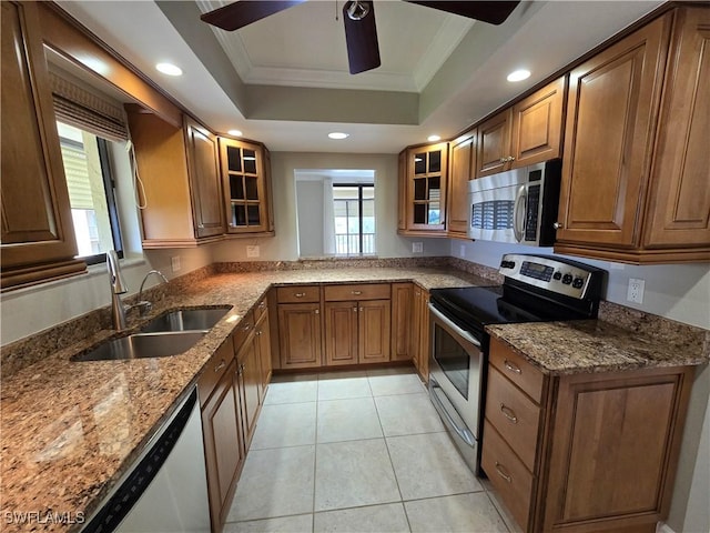 kitchen featuring sink, crown molding, light tile patterned floors, stainless steel appliances, and a tray ceiling