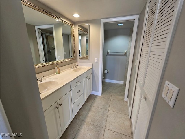 bathroom featuring vanity, tile patterned floors, and toilet