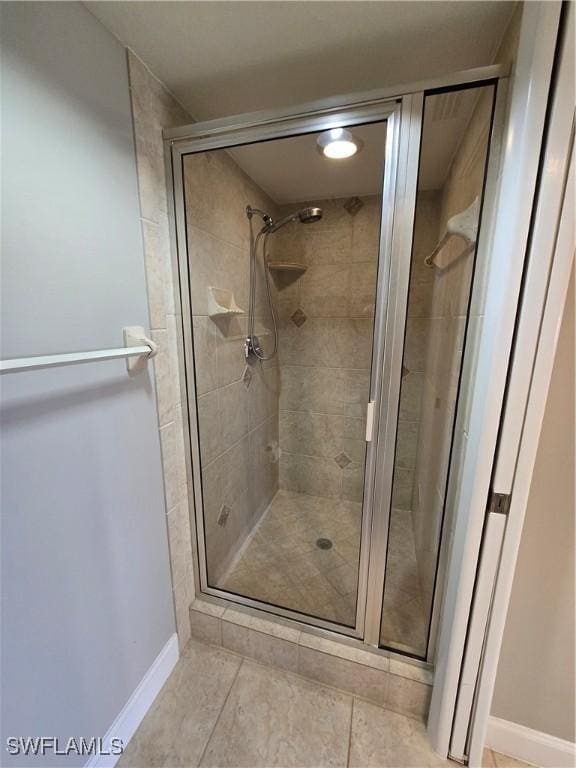 bathroom with an enclosed shower and tile patterned flooring