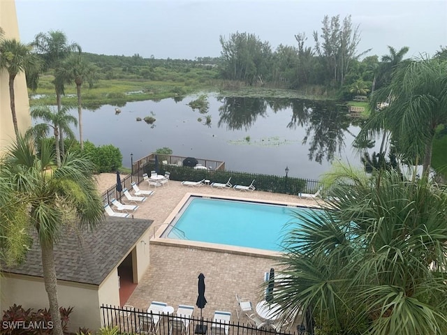 view of swimming pool with a water view and a patio area