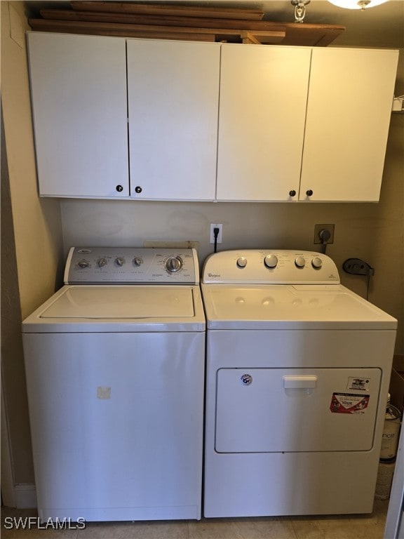 washroom with washing machine and dryer and cabinets