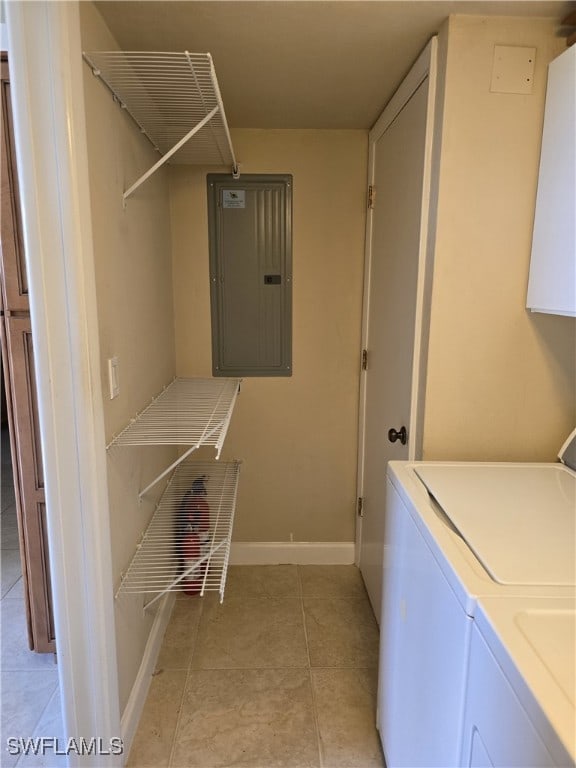 laundry area featuring light tile patterned floors, electric panel, and washer and clothes dryer