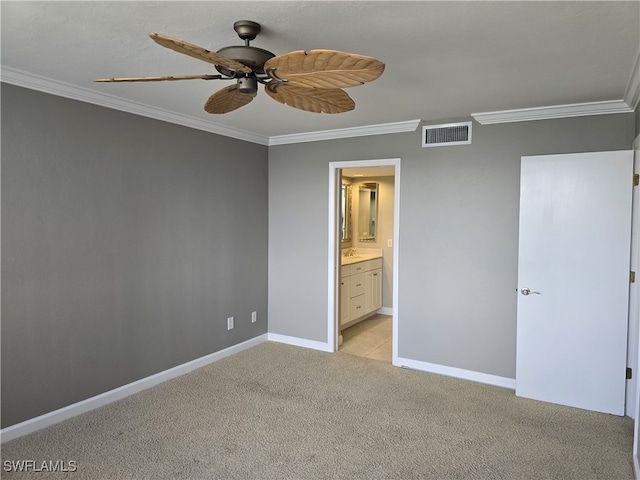 unfurnished bedroom with crown molding, ensuite bath, ceiling fan, and light carpet