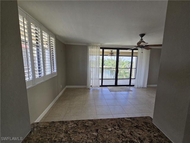 spare room featuring light tile patterned floors, crown molding, and ceiling fan