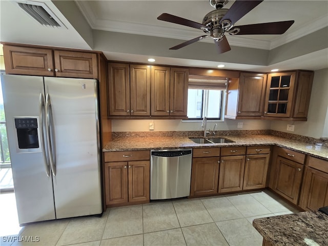 kitchen with sink, crown molding, light tile patterned floors, appliances with stainless steel finishes, and stone countertops